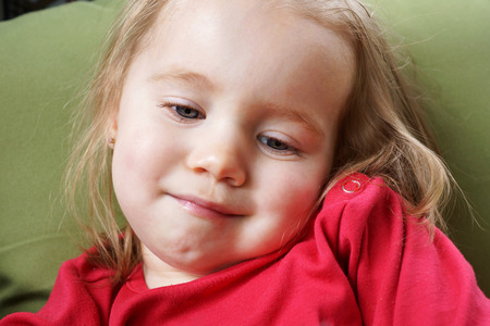 Portrait of a sleepy, smiling, blond baby girlの写真素材
