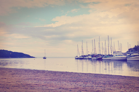 Sailboats in the harbor and beautiful beach- color filters effectの写真素材