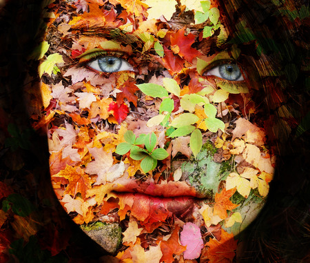 Sad face mother nature concept, woman with fall leaves textureの写真素材