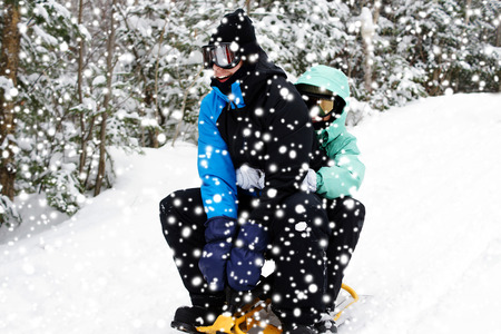 Young couple having fun sliding on the snow, winter sport conceptの写真素材