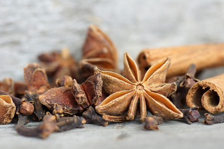 Anise star, cinnamon sticks, and cloves on old grey woodの写真素材