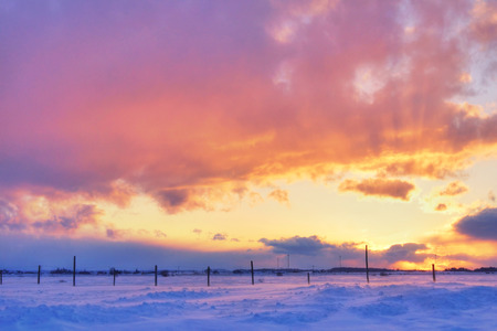 Beautiful sunset over snow on cold and windy winter dayの写真素材