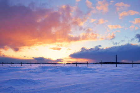 Beautiful sunset over snow on cold and windy winter dayの写真素材