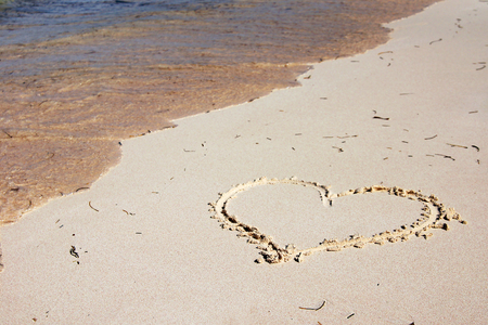 Heart drawn on the sandy beachの写真素材