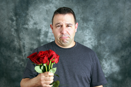 Sad lover or broken hearted man with roses conceptの写真素材