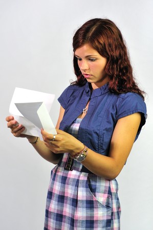 Young woman reading a serious letter, report, bill etc.の写真素材