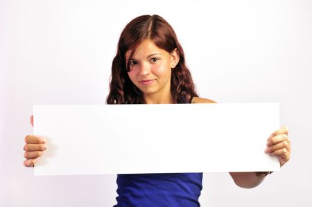 A pretty, smiling girl holding up a long white board. (Focus is on the board.)の写真素材