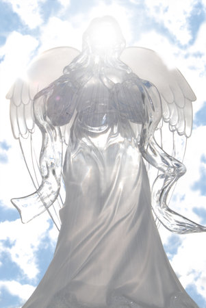 A glorious Angel floats suspended in the sky surrounding & radiating a brilliant white light as she prays to the Heavens above.の写真素材