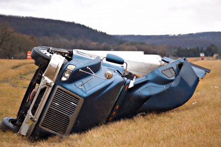 A tractor trailer on its side in the median after a roll over accident. の写真素材