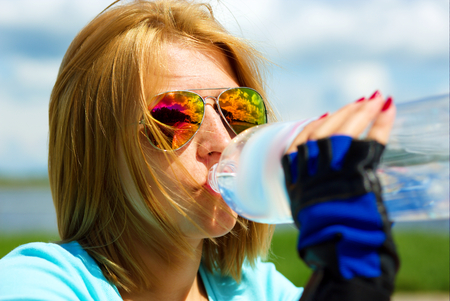 Portrait of cheerful young attractive woman drinking waterの写真素材