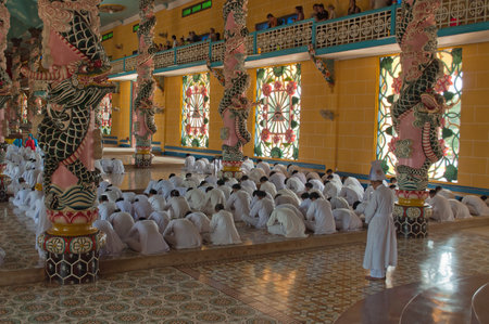 HO CHI MINH, VIETNAM - DEC 24: People praying in Cao Dai Temple on Dec 24, 2012, in Ho Chi Minh, Vietnam. Caodai is a Vietnamese religion mixing different religions from around the world, including Buddhism, Confucianism, Christianity, Hinduism, Islam, Juのeditorial素材