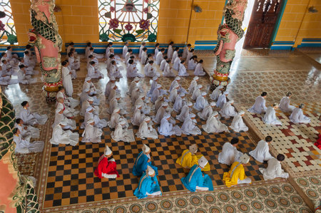 HO CHI MINH, VIETNAM - DEC 24: People praying in Cao Dai Temple on Dec 24, 2012, in Ho Chi Minh, Vietnam. Caodai is a Vietnamese religion mixing different religions from around the world, including Buddhism, Confucianism, Christianity, Hinduism, Islam, Juのeditorial素材