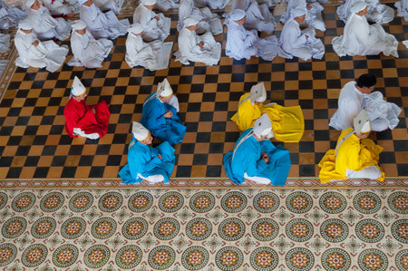  People praying in Cao Dai Temple on Dec 24, 2012, in Ho Chi Minh, Vietnam. Caodai is a Vietnamese religion mixing different religions from around the world, including Buddhism, Confucianism, Christianity, Hinduism, Islam, Judaism, Taoism, and Geniism.のeditorial素材