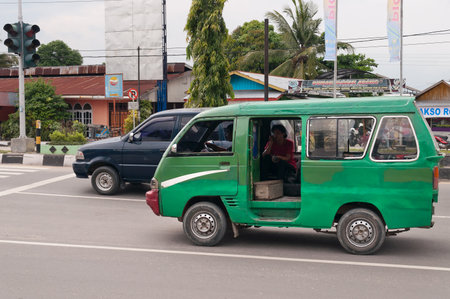 DUMAI, INDONESIA - DEC 21, 2013: Public transport on the street in Dumai.  Dumai is an important transport and trade centre, both regionally and internationallyのeditorial素材