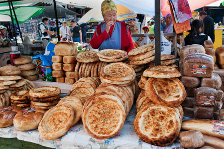 BOSTERI, KYRGYZSTAN - MAY 4, 2014: Kirghiz bread tokoch on Sunday market. Bosteri is a village in the Issyk Kul Province of Kyrgyzstan. It is a popular resort village where a lot of hotels, resortのeditorial素材