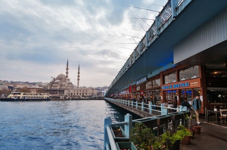 ISTANBUL, TURKEY, DEC 4, 2014:  Galata bridge and  New Mosque (Yeni Camii) in the evening. The Galata Bridge is a bridge that spans the Golden Hornのeditorial素材