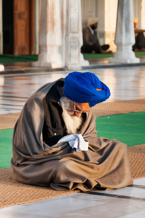 AMRITSAR, INDIA, DEC - 7, 2014: Unidentified Sikh man praying in Golden Temple (Harmandir Sahib also Darbar Sahib) in the early morning. Golden Temple is the holiest Sikh gurdwara located in the city of Amritsar, Punjab, India.のeditorial素材