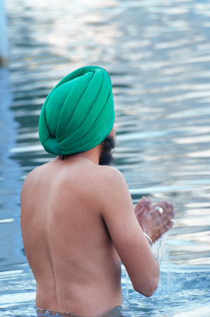 AMRITSAR, INDIA, DEC - 7, 2014: Unidentified Sikh man praying in the holy lake at Golden Temple (Harmandir Sahib also Darbar Sahib). Golden Temple is the holiest Sikh gurdwara located in the city of Amritsar, Punjab, India.のeditorial素材