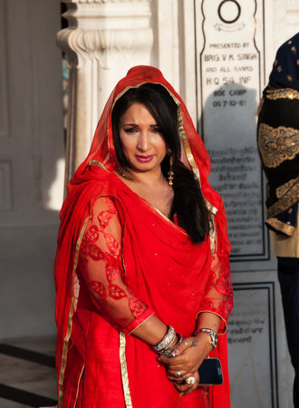AMRITSAR, INDIA, DEC - 7, 2014: Unidentified woman in a red saree  in Golden Temple (Harmandir Sahib also Darbar Sahib). Golden Temple is the holiest Sikh gurdwara located in the city of Amritsar, Punjab, India.のeditorial素材