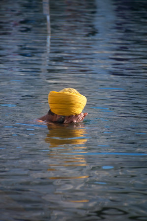 AMRITSAR, INDIA, DEC - 7, 2014: Unidentified Sikh man praying in the holy lake at Golden Temple (Harmandir Sahib also Darbar Sahib). Golden Temple is the holiest Sikh gurdwara located in the city of Amritsar, Punjab, India.のeditorial素材