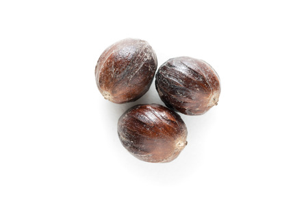 Three nutmeg nut isolated on white backgroundの写真素材