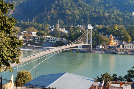 RISHIKESH, INDIA - DEC 11, 2014: View of River Ganga and Ram Jhula bridge. Rishikesh is  World...