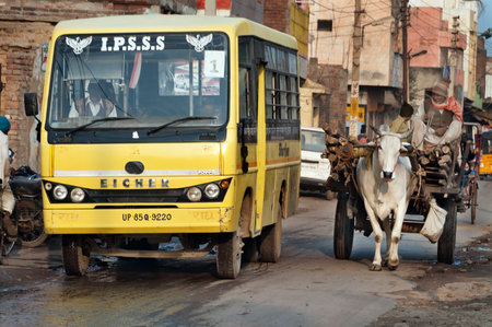 VRINDAVAN, INDIA - DEC 15, 2014:  Bullock cart and bus on the road. Vrindavan is considered to be a holy place. The major tradition followed in the area is Vaisnavism. It is the place where Krishna spent his childhood days.のeditorial素材