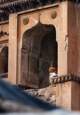 ORCHHA, INDIA - DEC 19, 2014: Unidentified Indian Sadhu sitting at window of Chaturbhuj Temple. Orchha is a town in Madhya Pradesh state. The town was established by Maharaja Rudra Pratap Singh in 1501のeditorial素材