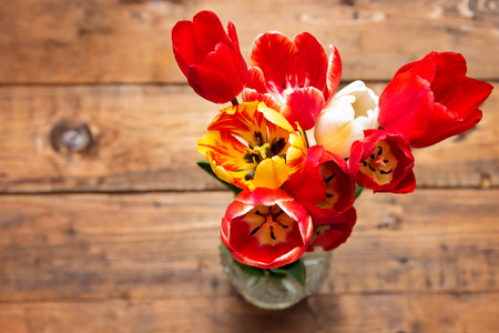 Beautiful different tulips  in vase on wood backgroundの写真素材