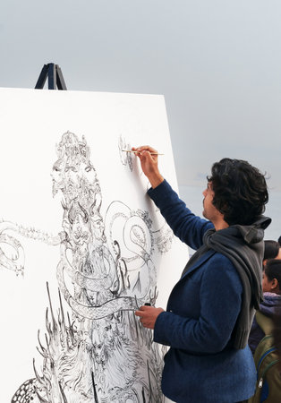 VARANASI, INDIA - DEC 23, 2014: Unidentified Indian painter draws a picture on the ghat near sacred river Ganges in Varanasi. Uttar Pradesh, Indiaのeditorial素材