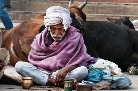 VARANASI, INDIA - DEC 23, 2014: Unidentified Indian man sits on the ghat near sacred river Ganges in Varanasi. Uttar Pradesh, Indiaのeditorial素材