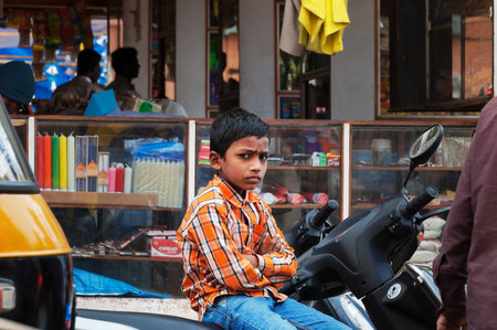 BANGALORE, INDIA - DEC 25, 2014:  Unidentified Indian young boy sitting on the bike at the Russell market. Russell Market is a shopping market in Bangalore, built in 1927 by the British.のeditorial素材