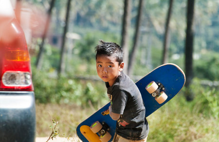 BANGALORE, INDIA - DEC 26, 2014: Unidentified Indian boy with  skateboard on the street in Bangalore.  Karnataka. Indiaのeditorial素材