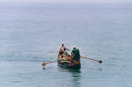 KOVALAM, INDIA - DEC 28, 2014: Traditional wooden fishing boats in the ocean. Kovalam. Kerala. Indiaのeditorial素材