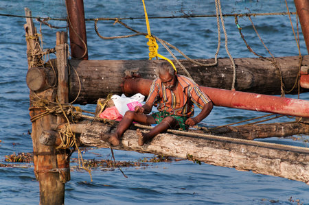 Fort Kochi, India - Jan 6, 2015: Unidentified Indian Fisherman  on Chinese Fishing nets in Fort Kochi. Kerala. Indiaのeditorial素材