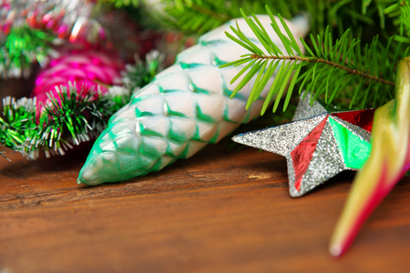 Branch of green fir tree with christmas toys on wooden backgroundの写真素材