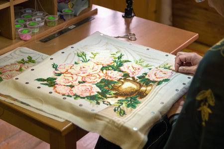 Gorodets,  Russia - May 3, 2015: Girl doing embroidery vase with flowers at City of Craftsmen....