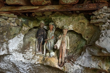Wooden statues of Tau Tau in Tampang Allo burial cave of the royal family. There are pile of skulls by the entrance, coffins are placed in caves or hanging from the cliff. Tana Toraja. South Sulawesi. Indonesiaの写真素材
