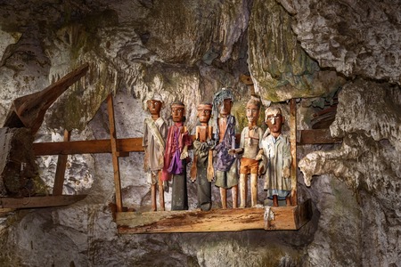 Wooden statues of Tau Tau in Tampang Allo burial cave of the royal family. There are pile of skulls by the entrance, coffins are placed in caves or hanging from the cliff. Tana Toraja. South Sulawesi. Indonesiaの写真素材