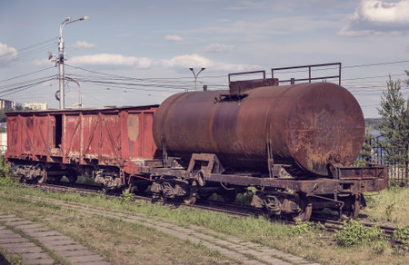 Old covered goods wagon and tank car. Old industrial railway cars on on Mining and metallurgical plantのeditorial素材