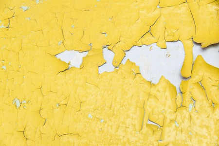 Old peeling yellow painted wall background textureの写真素材