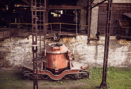 Old steel buckets to transport the molten iron, mounted on railway platforms in blast furnace workshop on Mining and metallurgical plantの写真素材