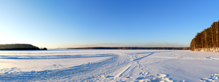 Panorama of the frozen pond in winter at sunny dayの写真素材