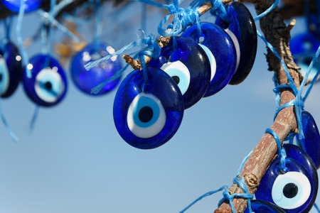 Nazars, Turkish Evil eye charms on the branches of tree on blue sky background. Cappadocia. Nevsehir Province. Turkeyの写真素材