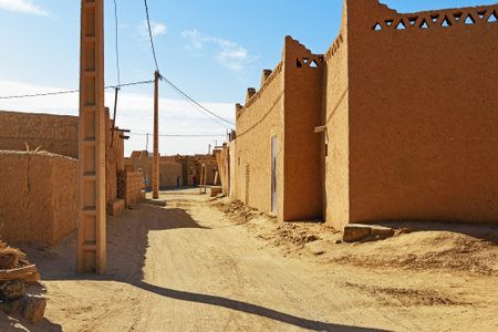 Merzouga, Morocco - Jan 6, 2017: On the street in Merzouga village. Two Moroccan men in white djellaba talk on the streetのeditorial素材