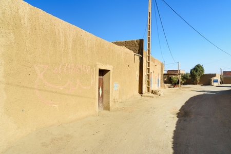 Merzouga, Morocco - Jan 6, 2017: On the street in Merzouga village. Two Moroccan men in white djellaba talk on the streetのeditorial素材