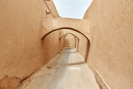 Narrow street with arches of old adobe Yazd city. Iranの写真素材