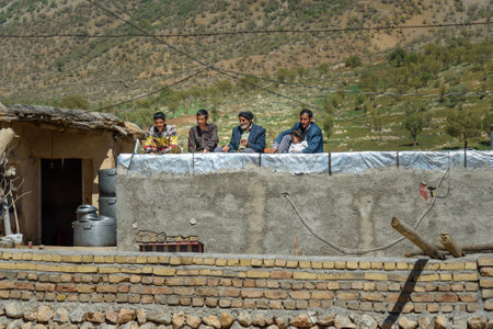 Lorestan Province, Iran - April 1, 2018: Iranian men are watching the wedding from the roof in the villageのeditorial素材