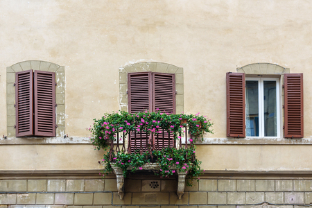 Traditional windows and balcony with wooden shutters of old house in Siena. Italyの写真素材