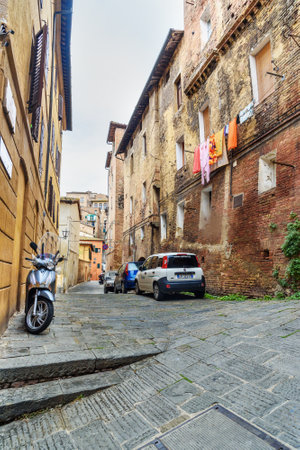 Siena, Italy - October 02, 2018: Medieval narrow street Via Lombarde in old city Sienaのeditorial素材